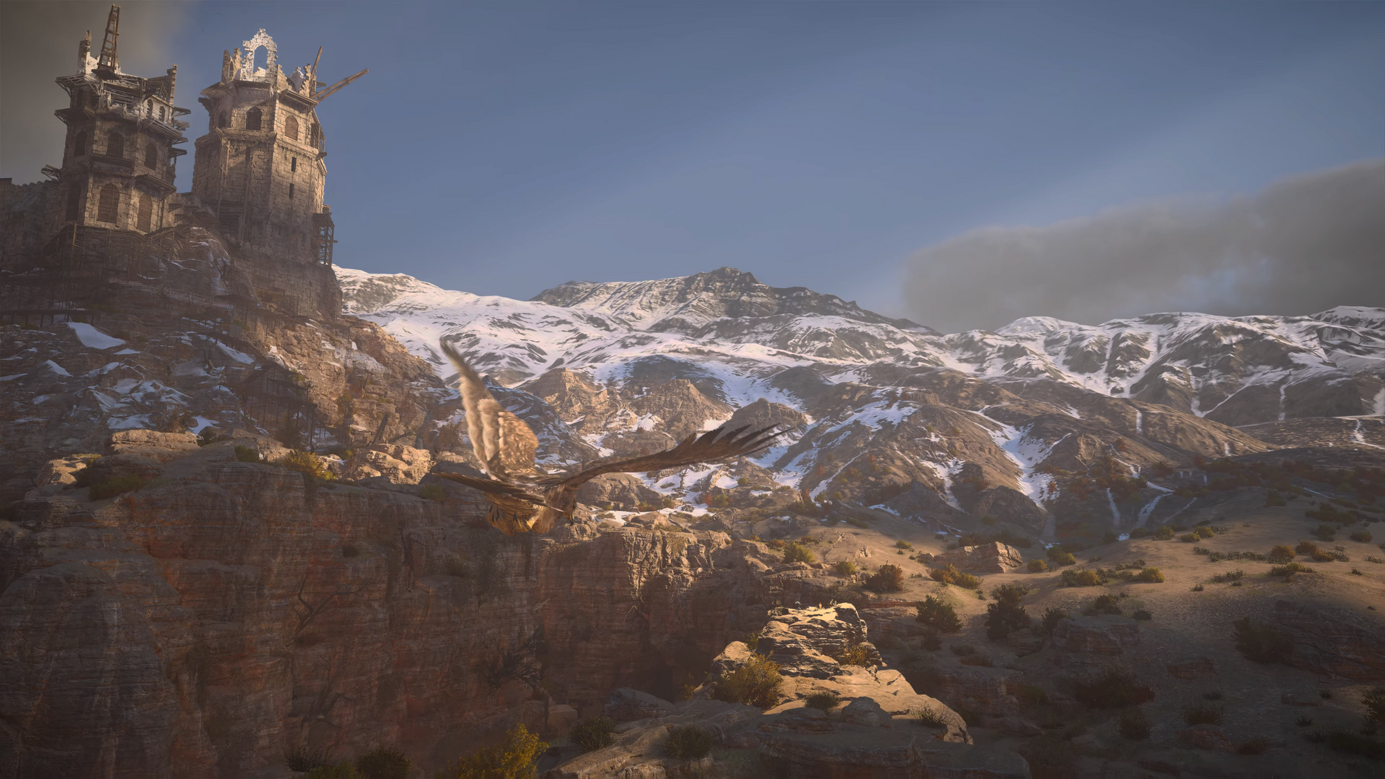 A hawk is seen swooping over a valley bordered by white-capped mountains. To the left a crumbling masonry temple or fortress stands towering above on a bluff.