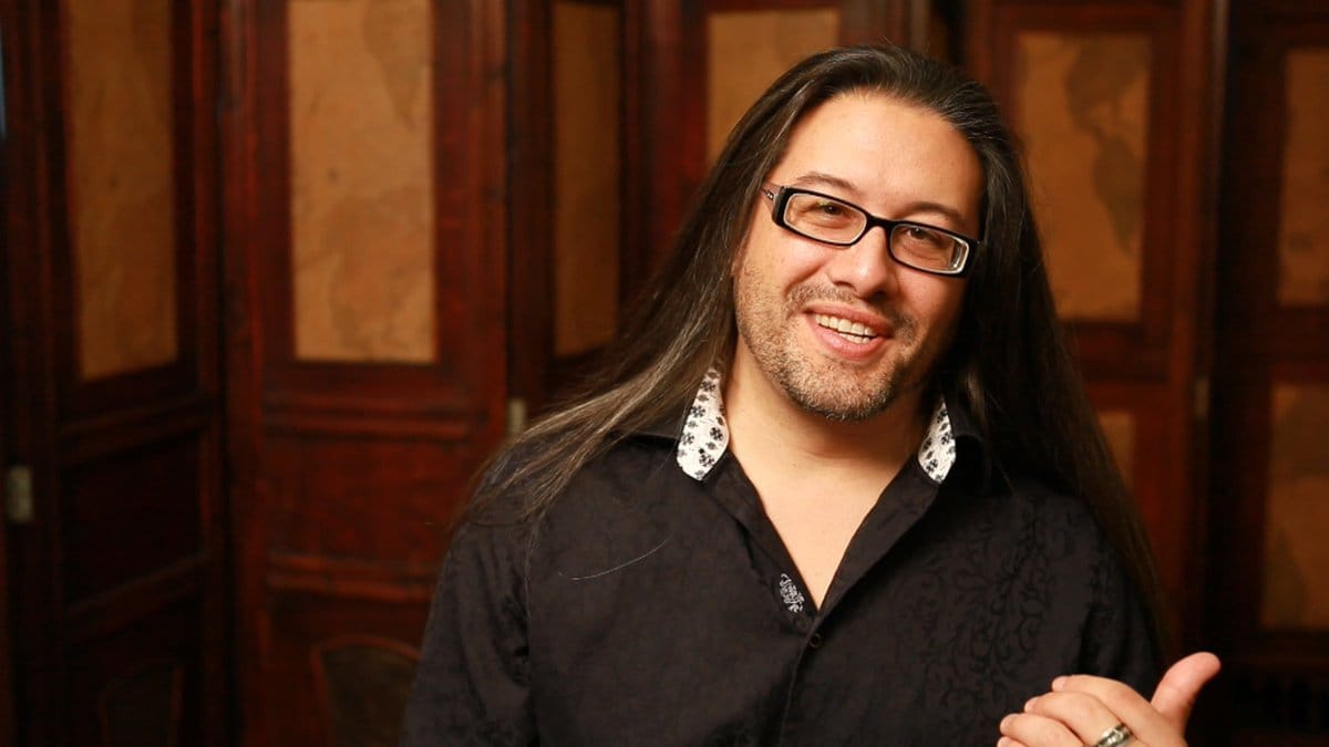 A picture of John Romero half smiling at the camera