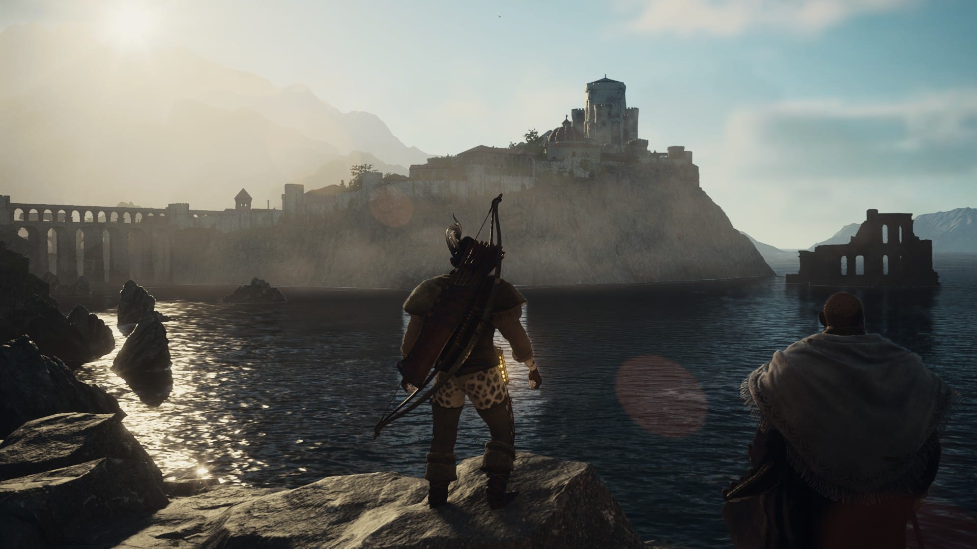 An archer stands on a rocky outcrop in a placid ocean bay looking across at a city on a peninsula.