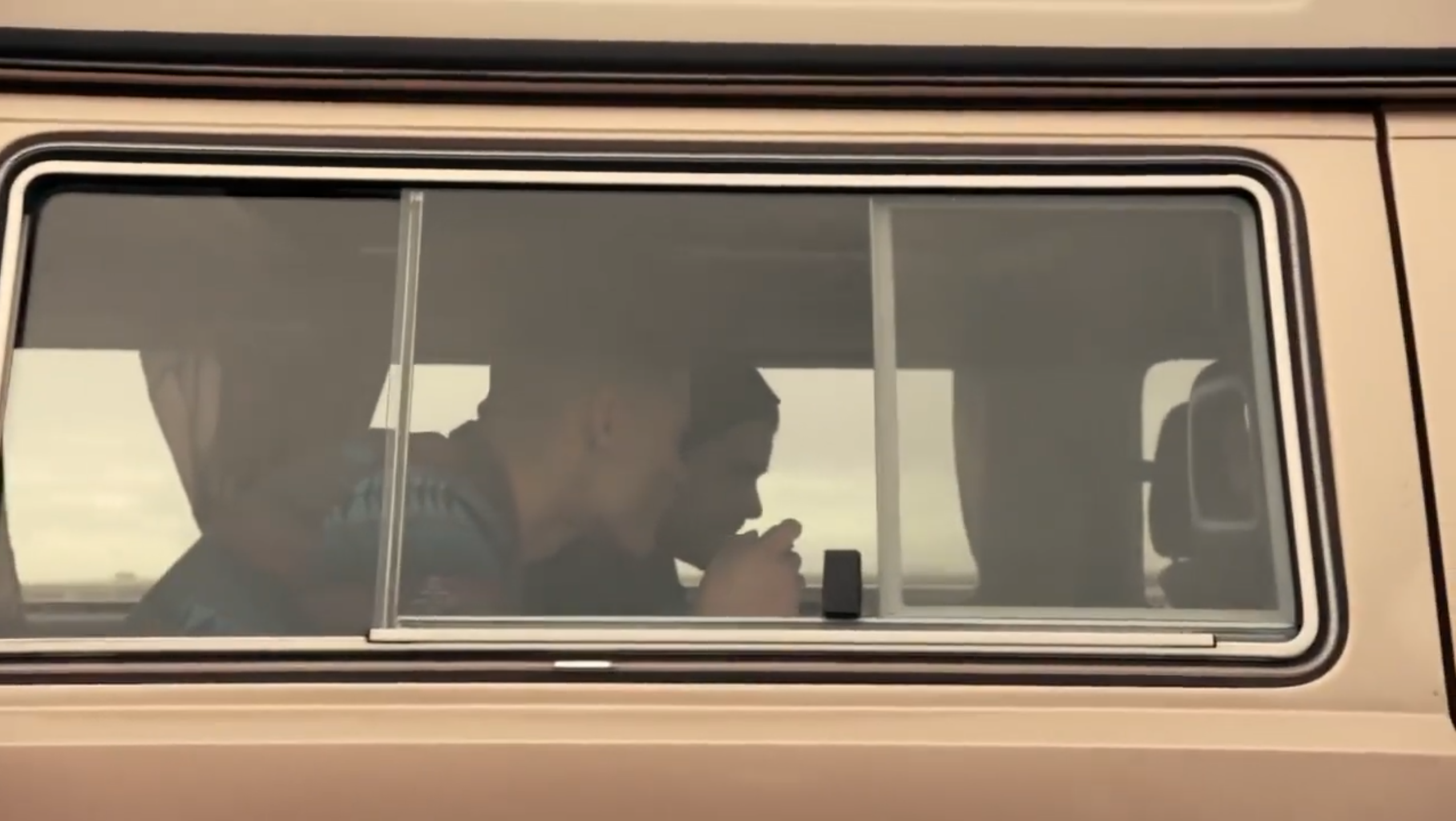 A still from the Switch ad showing guys playing Mario Kart in their brown VW Bus.